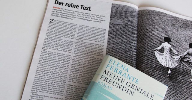 Das Buch »Meine Geniale Freundin« liegt auf einer aufgeklappten Zeitschrift, in der ein Interview mit Elena Ferrante abgedruckt ist.