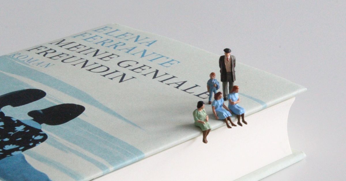 Ausschnitt des Buches »Meine Geniale Freundin«, auf dem fünf Miniaturfiguren sitzen und stehen.
